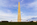 View of the gleaming white stone of the Washington Monument towards dusk including fifty American flagpoles encircling the base, The Mall, Washington DC