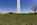 Ground level scene from the Mall in Washignton DC, featuring the bottom-section of the Washington Monument including American flagpoles