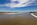 A low-tide summertime seascape and mountainscape from Cymyran Bay, featuring the seaside tourist village of Rhosneigr and Snowdonia Mountain range, Anglesey, Gwynedd