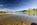 A summertime beachscape and coastline scene from Red Wharf Bay featuring a view of the hamlet of Red Wharf Bay in the distance, Area of Outstanding Natural Beauty, Isle of Anglesey, North Wales