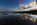 A beautiful low-light beachscape, seascape and cloudscape reflection from Red Wharf Bay featuring salt marsh, sand dunes and the headland at Llanddona, Isle of Anglesey, North Wales