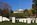 Autumn scene featuring the iconic simple marble headstones lining the gently sloping hills of Arlington National Cemetery including Arlington House perched atop a hill in the military cemetery in Virginia