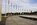 Summer scene from the circular paved pedestrian plaza at the base of the Washington Monument featuring American flagpoles, visitor groups and the US Capitol in the distance, National Mall, Washington DC