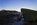 A low-light coastline scene from Red Wharf Bay featuring a boat and a view of the hamlet Red Wharf Bay in the distance, Area of Outstanding Natural Beauty, Anglesey, Gwynedd