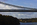 Telephoto lens view from the mainland-side of the Menai Suspension Bridge featuring a view of the suspended section of the World Heritage Site and Britannia Bridge in the distance, Gwynedd, North Wales