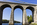 Historic scene from the Isle of Anglesey featuring the Menai Bridges including the imposing stone arches of the Menai Suspension Bridge and Britannia Bridge in the distance, Gwynedd, North Wales